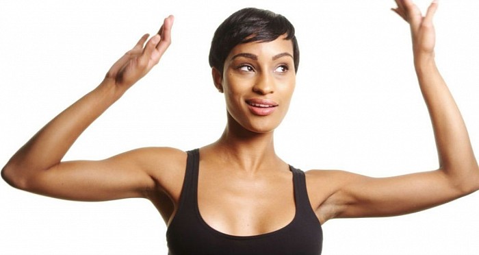 An afro brunette is dancing with smile.