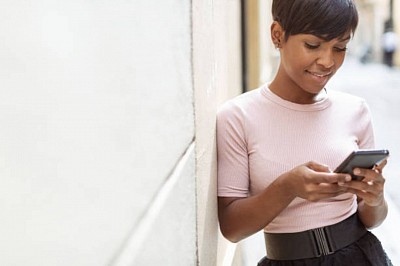 An african american woman is chatting with smartphone.