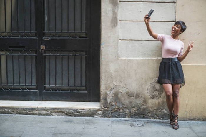 An african american woman is taking selfie from her smartphone.