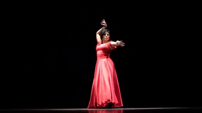 An attractive dancer is dancing flamenco.