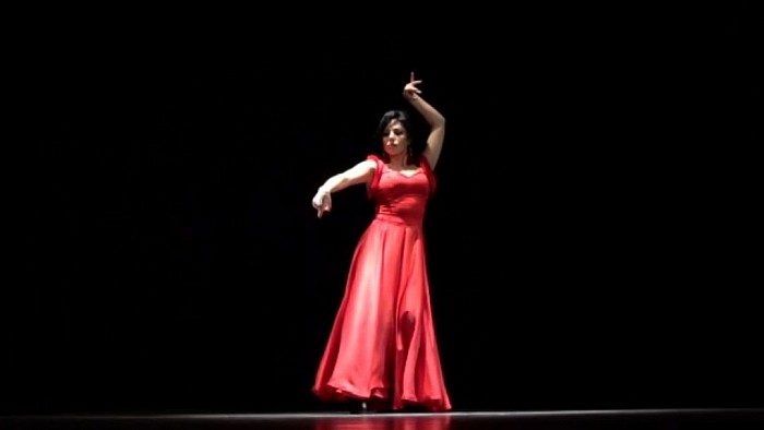 A beautiful female bailaora (flamenco dancer)is dancing argentine flamenco dance.